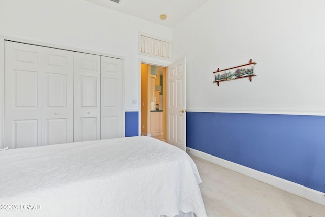 carpeted bedroom featuring a closet and vaulted ceiling