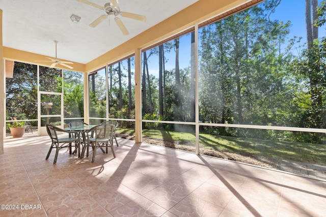 unfurnished sunroom with ceiling fan