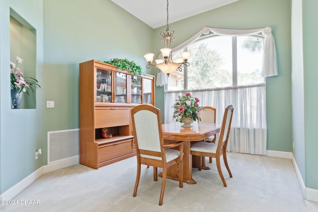 dining area featuring light carpet and a notable chandelier