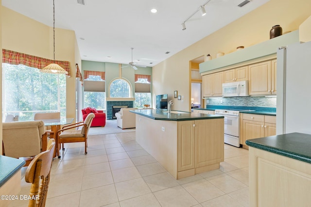 kitchen with a fireplace, hanging light fixtures, sink, white appliances, and ceiling fan