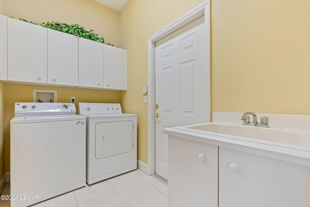 laundry room with light tile patterned flooring, cabinets, sink, and washer and dryer