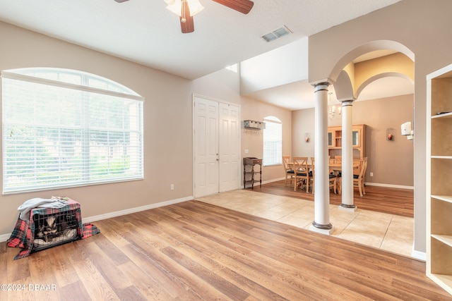 interior space featuring a healthy amount of sunlight, ornate columns, and light hardwood / wood-style flooring