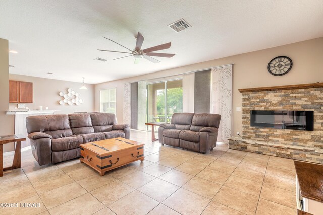 206 Laurel Point Ct, Deland, FL 32724 - living room featuring ceiling fan, light tile patterned flooring, and a stone fireplace