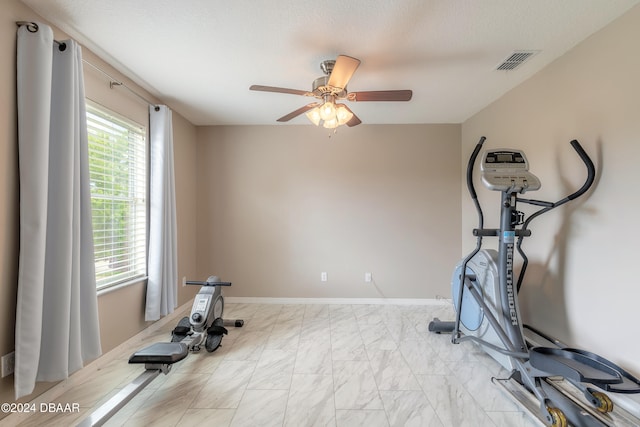 workout room with a textured ceiling and ceiling fan