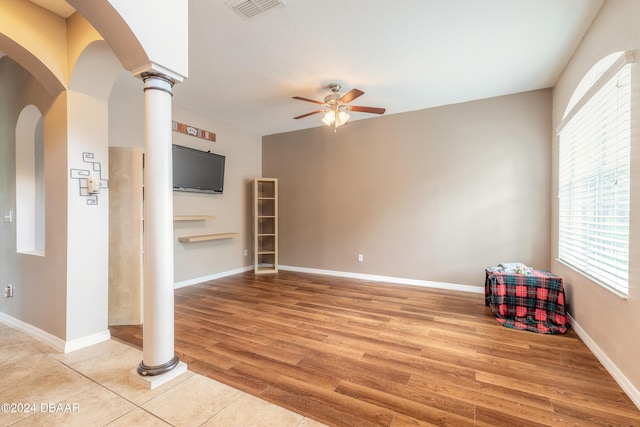 interior space featuring decorative columns, ceiling fan, and light hardwood / wood-style floors