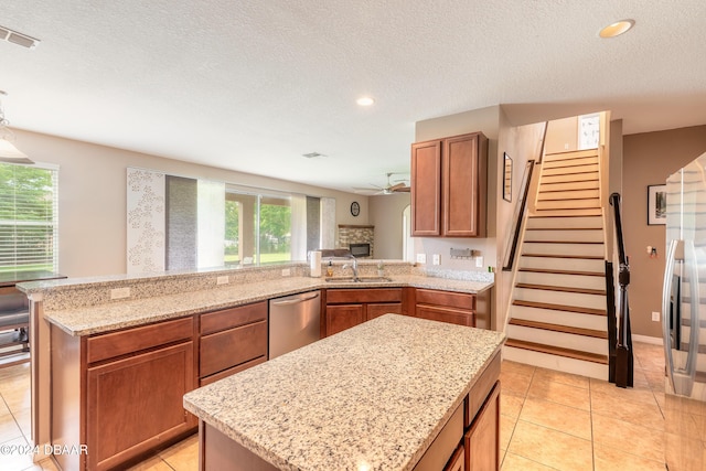 206 Laurel Point Ct, Deland, FL 32724 - kitchen with stainless steel dishwasher, a sink, light stone countertops, a ceiling fan, and a peninsula