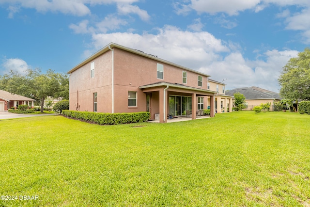 rear view of property featuring a patio and a lawn