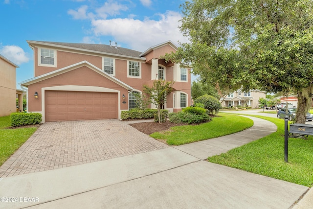 206 Laurel Point Ct, Deland, FL 32724 - view of front of house with decorative driveway, a front yard, stucco siding, and a garage