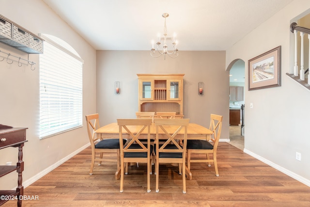 dining area with hardwood / wood-style floors and a notable chandelier