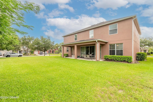 206 Laurel Point Ct, Deland, FL 32724 - back of house featuring a patio area, stucco siding, and a lawn