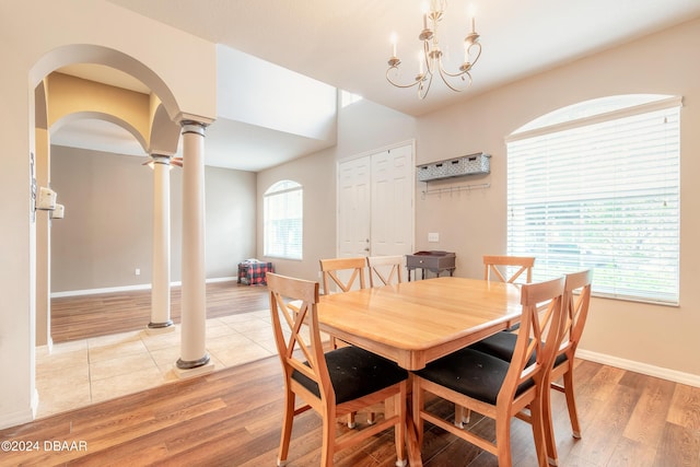 206 Laurel Point Ct, Deland, FL 32724 - dining area with ornate columns, light wood finished floors, a chandelier, and arched walkways