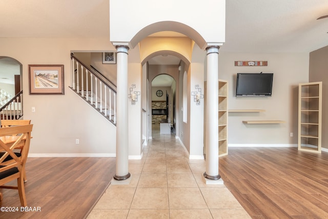 foyer featuring light hardwood / wood-style floors and ornate columns