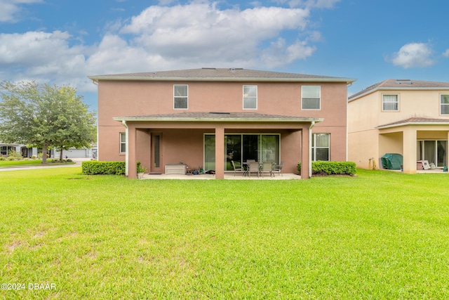 rear view of house with a patio and a yard