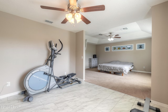 bedroom with ceiling fan, light carpet, and a tray ceiling