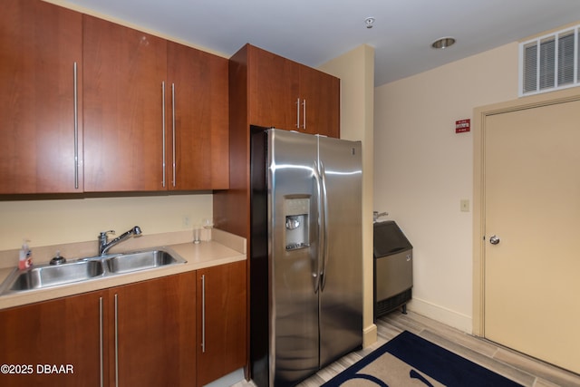 kitchen with sink and stainless steel refrigerator with ice dispenser