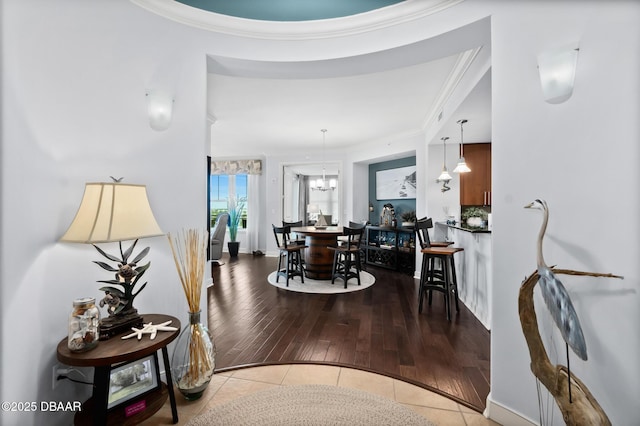 interior space with crown molding, light tile patterned floors, and an inviting chandelier