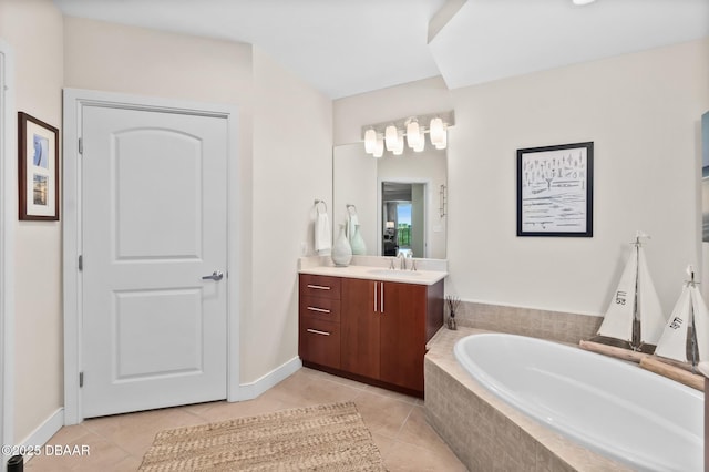 bathroom featuring tile patterned flooring, vanity, and tiled tub