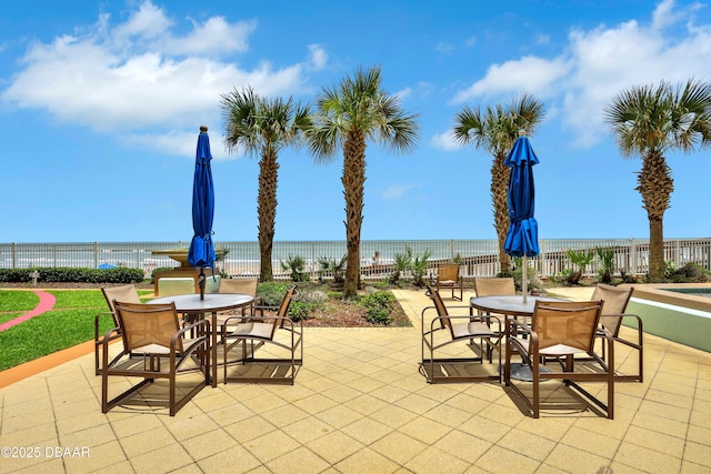 view of patio with a water view and a view of the beach