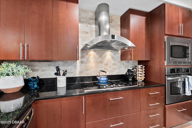 kitchen with dark stone countertops, appliances with stainless steel finishes, backsplash, and wall chimney range hood