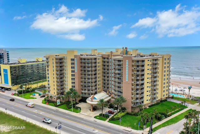 view of building exterior with a water view and a view of the beach