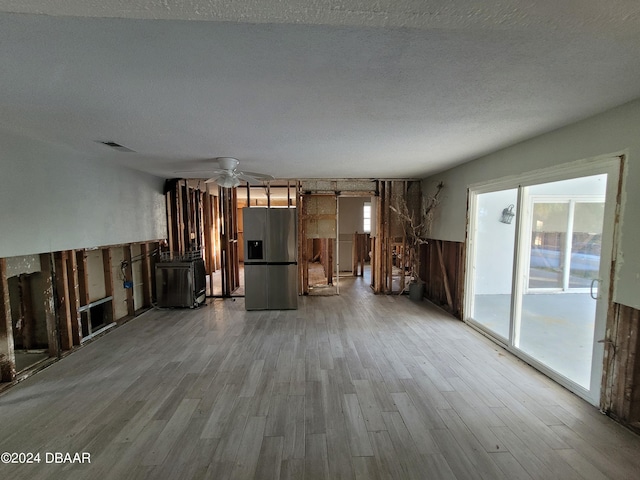 223 Clark Pl, Port Orange, FL 32127 - unfurnished living room with a ceiling fan, wood finished floors, visible vents, and a textured ceiling