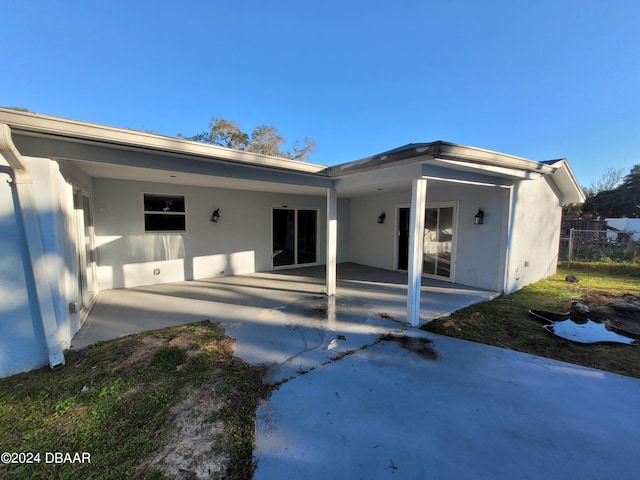 223 Clark Pl, Port Orange, FL 32127 - rear view of property with fence, stucco siding, and a patio