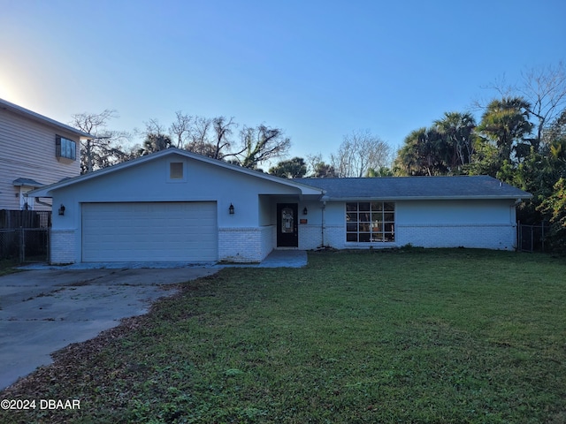 223 Clark Pl, Port Orange, FL 32127 - view of front facade featuring brick siding, a garage, a front lawn, and fence