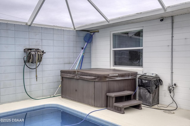 exterior space with glass enclosure, a grill, and a hot tub