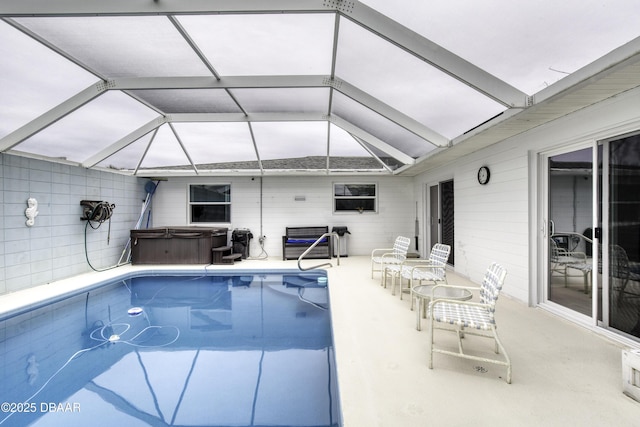 view of swimming pool featuring a lanai, a hot tub, and a patio