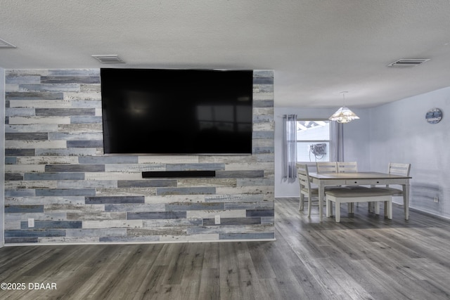 room details with a textured ceiling, an inviting chandelier, and hardwood / wood-style floors