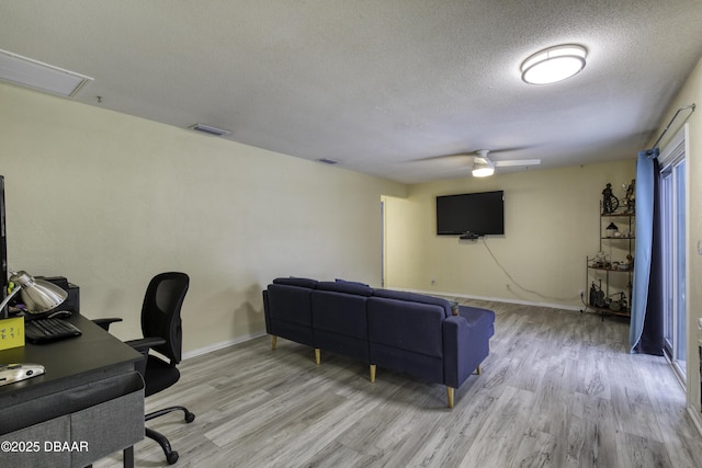 home office featuring a textured ceiling, ceiling fan, and light hardwood / wood-style flooring