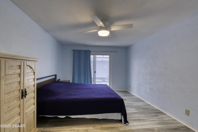 bedroom featuring ceiling fan, light hardwood / wood-style floors, and a textured ceiling