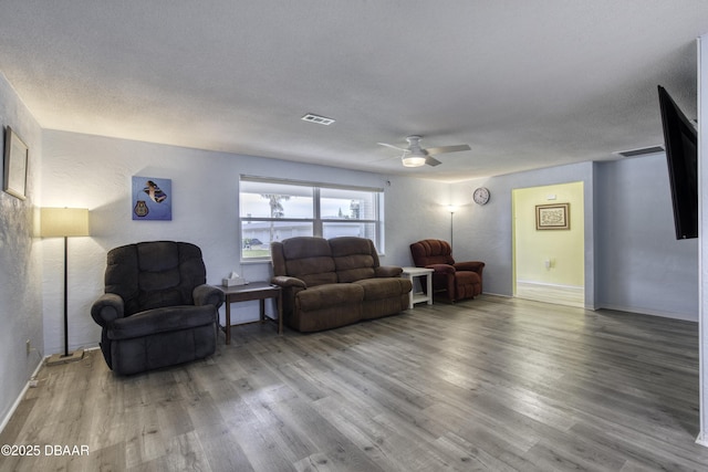 living room featuring a textured ceiling, ceiling fan, and hardwood / wood-style floors