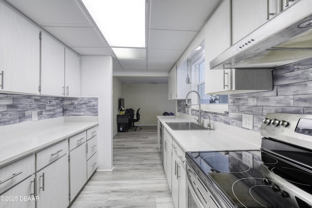 kitchen with white cabinetry, tasteful backsplash, sink, stainless steel range with electric stovetop, and light wood-type flooring