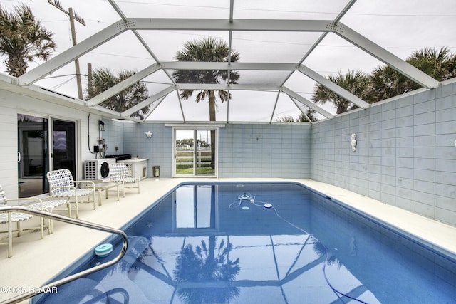 view of pool with ac unit, a patio, and glass enclosure