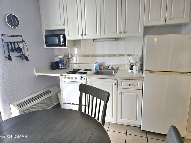 1233 S Atlantic Ave Unit 5270, Daytona Beach, FL 32118 - kitchen with light tile patterned floors, white appliances, a sink, white cabinetry, and light countertops