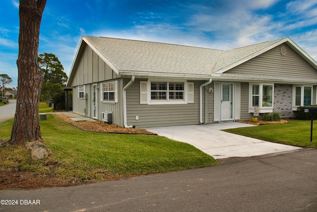 view of front of home featuring central AC and a front lawn