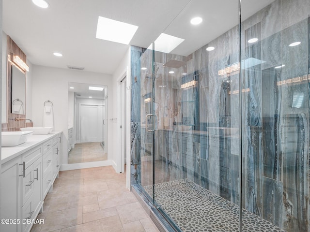 1601 S Riverside Dr, Edgewater, FL 32132 - bathroom with a skylight, recessed lighting, a stall shower, double vanity, and baseboards
