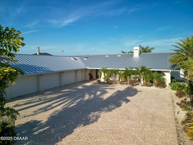 1601 S Riverside Dr, Edgewater, FL 32132 - view of front of property featuring metal roof, an attached garage, a chimney, and a standing seam roof