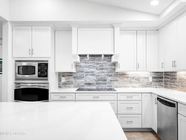 1601 S Riverside Dr, Edgewater, FL 32132 - kitchen featuring appliances with stainless steel finishes, light countertops, backsplash, white cabinets, and lofted ceiling