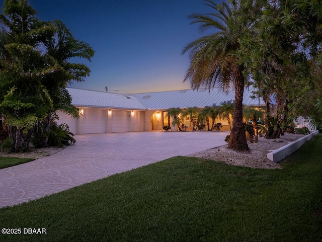1601 S Riverside Dr, Edgewater, FL 32132 - view of front of home featuring a front yard, driveway, a garage, metal roof, and a standing seam roof