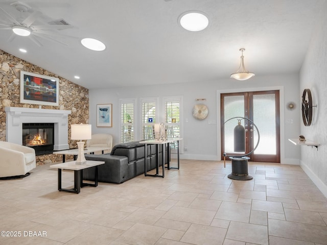 1601 S Riverside Dr, Edgewater, FL 32132 - living room with vaulted ceiling, ceiling fan, a glass covered fireplace, baseboards, and french doors