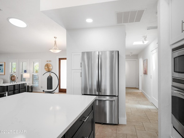 1601 S Riverside Dr, Edgewater, FL 32132 - kitchen with stainless steel appliances, light countertops, pendant lighting, dark cabinets, and baseboards