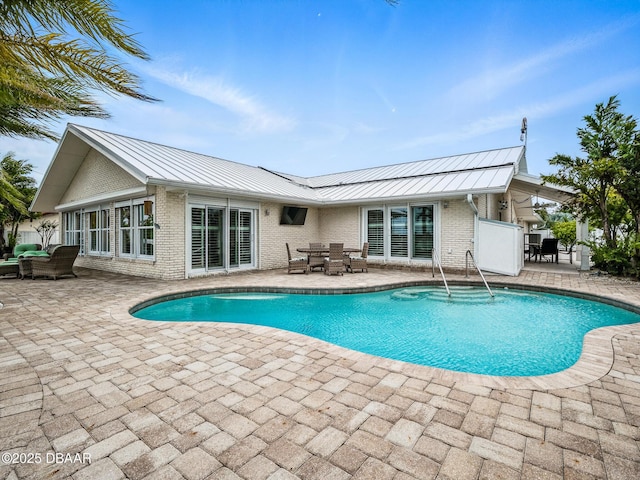 1601 S Riverside Dr, Edgewater, FL 32132 - rear view of house with a standing seam roof and a patio