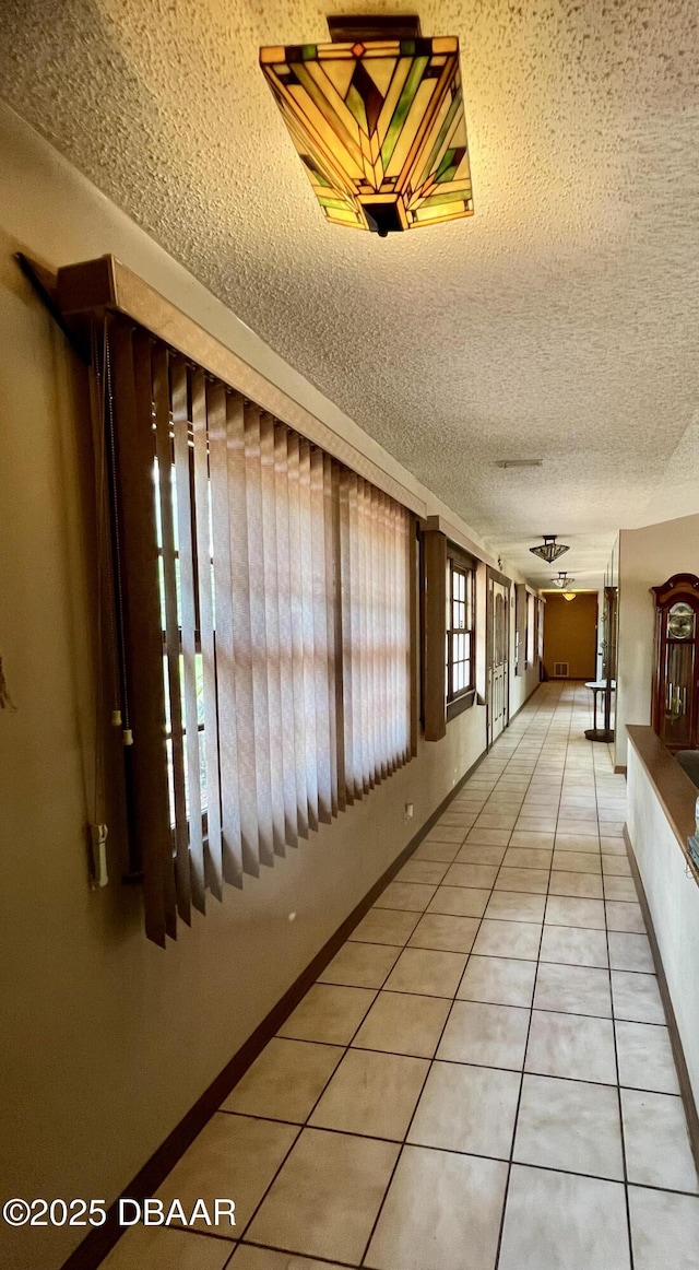 11 Winchester Rd, Ormond Beach, FL 32174 - hall with tile patterned flooring, a textured ceiling, and baseboards