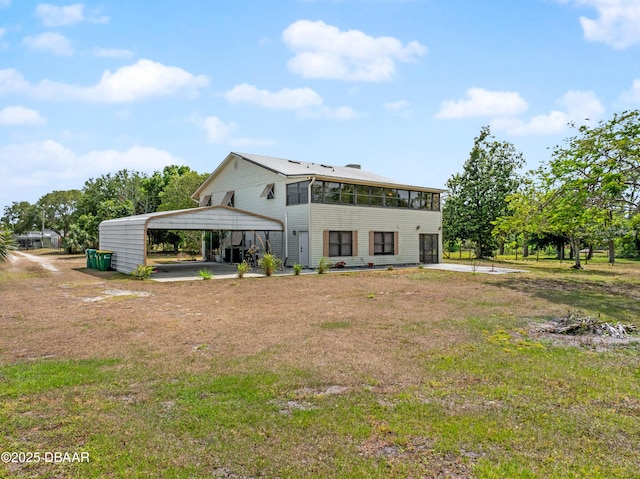 350 Citrus Club Dr, Merritt Island, FL 32953 - back of house with a lawn, a detached carport, and driveway