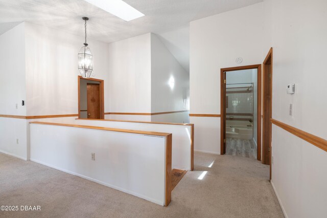 350 Citrus Club Dr, Merritt Island, FL 32953 - hall with carpet floors, a skylight, an upstairs landing, baseboards, and lofted ceiling