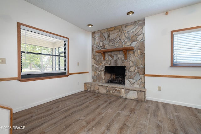 350 Citrus Club Dr, Merritt Island, FL 32953 - unfurnished living room with a fireplace, wood finished floors, baseboards, and a textured ceiling