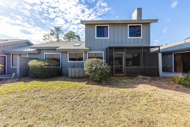 back of property featuring a lawn and a sunroom