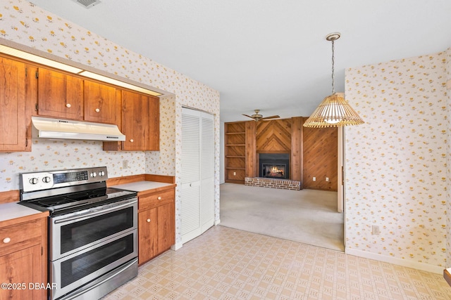 kitchen with range with two ovens, light carpet, ceiling fan, and decorative light fixtures